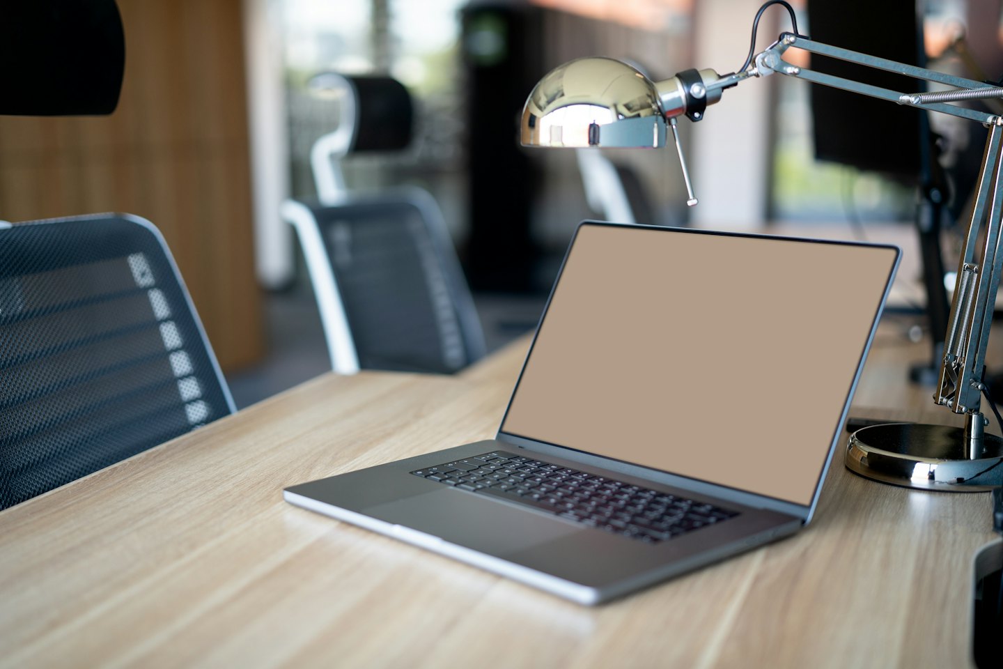 Na světlém dřevěném stole leží moderní notebook.